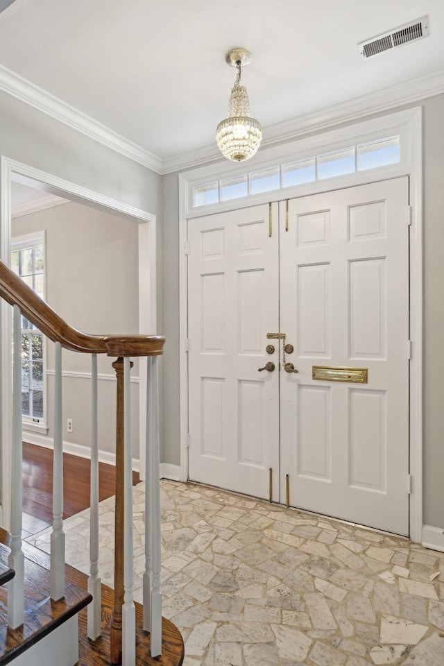 entrance foyer with visible vents, baseboards, crown molding, and stairway