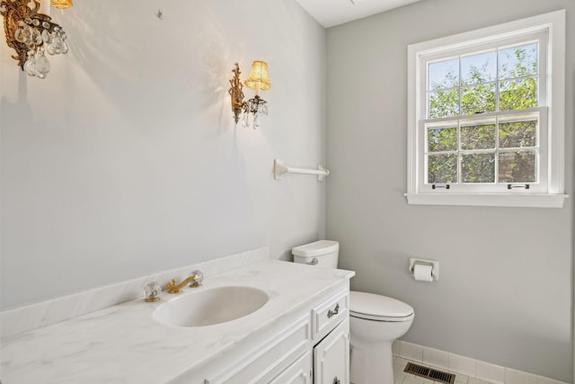 bathroom with vanity, baseboards, visible vents, tile patterned floors, and toilet