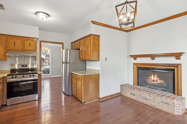 kitchen featuring under cabinet range hood, a notable chandelier, appliances with stainless steel finishes, and dark wood-style flooring