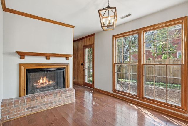 unfurnished living room featuring visible vents, baseboards, a fireplace, and hardwood / wood-style flooring