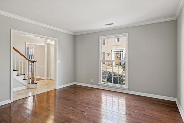 spare room featuring visible vents, dark wood-type flooring, and a healthy amount of sunlight