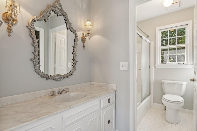 bathroom featuring vanity, baseboards, tile patterned flooring, toilet, and combined bath / shower with glass door