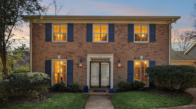 colonial-style house with brick siding