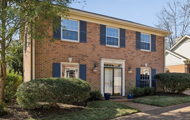 colonial-style house featuring brick siding