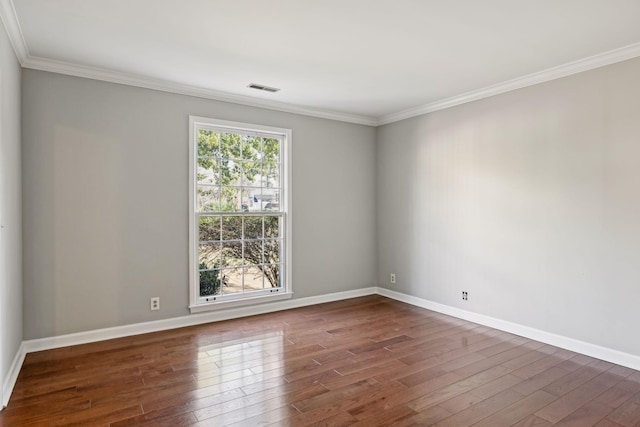 unfurnished room featuring a wealth of natural light, visible vents, and wood finished floors