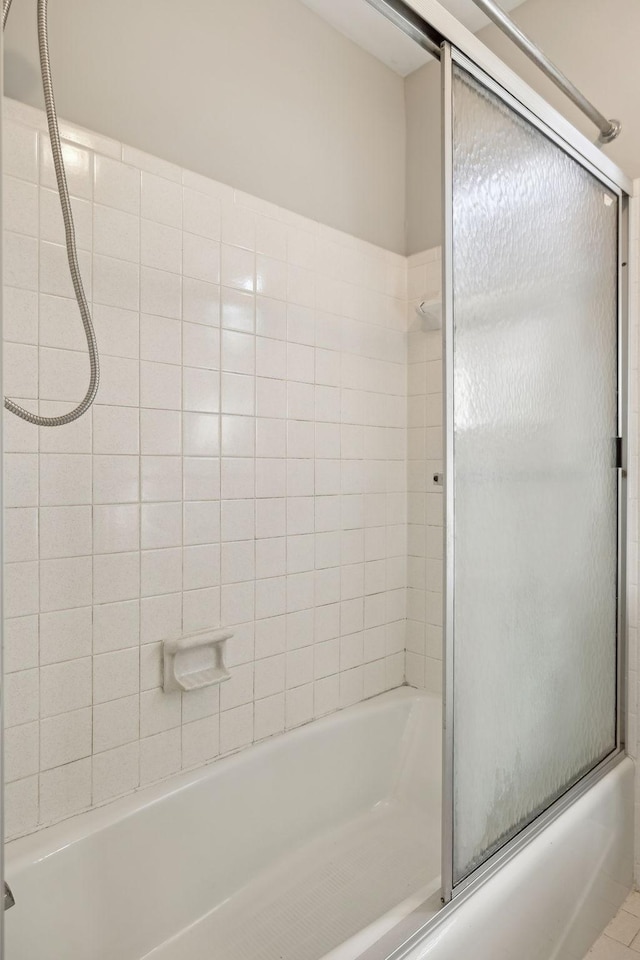 full bath featuring bath / shower combo with glass door