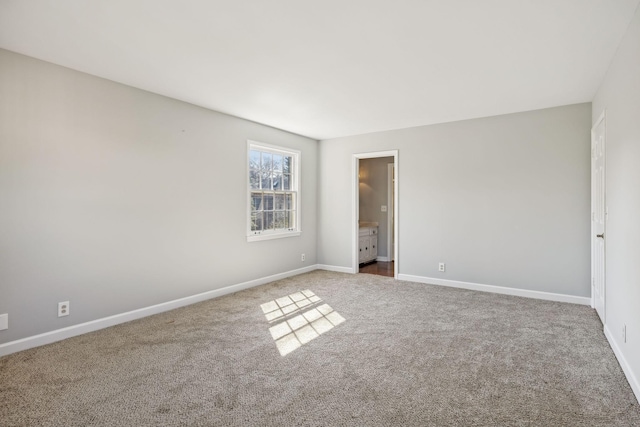 unfurnished bedroom with carpet flooring, connected bathroom, and baseboards