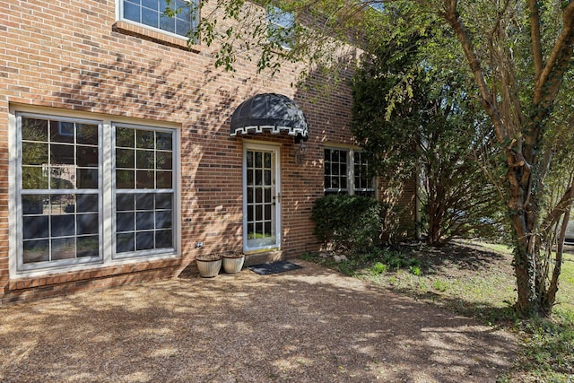 entrance to property featuring brick siding