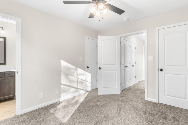 unfurnished bedroom with a ceiling fan, light colored carpet, baseboards, and connected bathroom