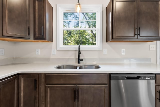 kitchen with stainless steel dishwasher, dark brown cabinetry, and a sink