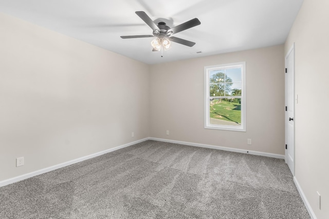 carpeted spare room featuring baseboards and a ceiling fan