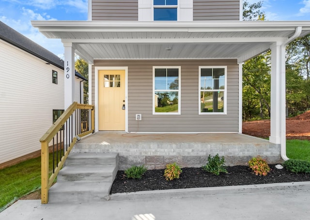 view of exterior entry featuring covered porch