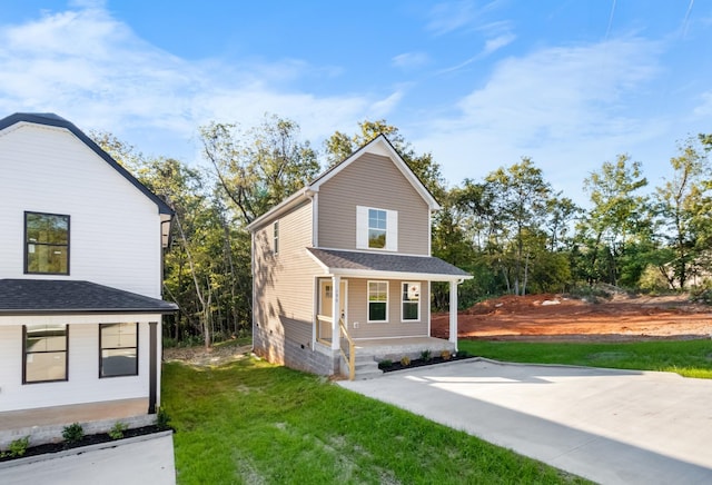 view of front of house featuring a front lawn and roof with shingles