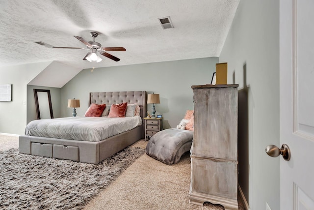 bedroom with a ceiling fan, carpet, visible vents, vaulted ceiling, and a textured ceiling