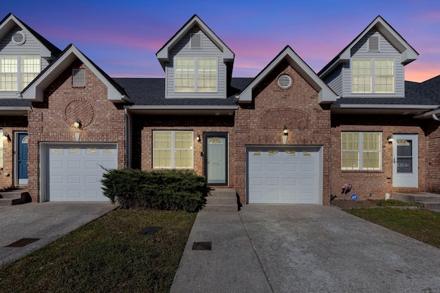 view of front facade with a garage, brick siding, driveway, and roof with shingles