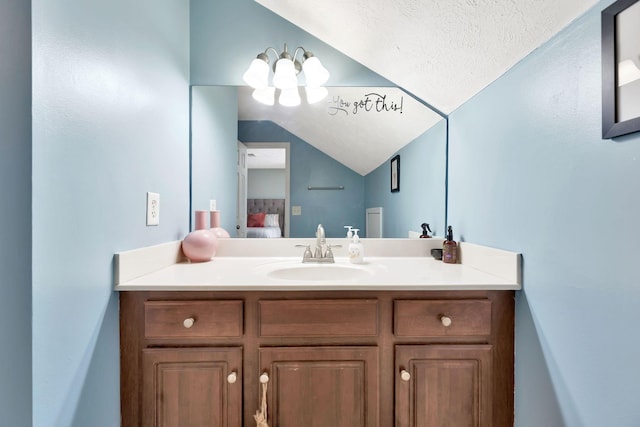 bathroom featuring connected bathroom, lofted ceiling, a textured ceiling, and vanity