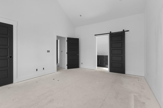 interior space with a barn door and high vaulted ceiling