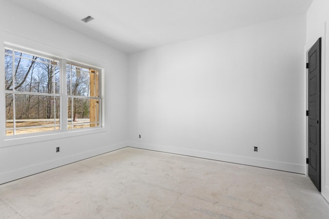 spare room featuring baseboards and concrete flooring