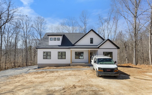 modern farmhouse style home featuring driveway and roof with shingles