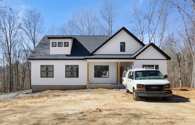 modern farmhouse style home with a shingled roof