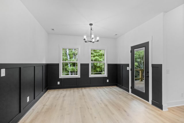 4410 Shiloh Canaan Rd, Palmyra, TN 37142 - unfurnished dining area with light wood-style floors, a chandelier, and a wainscoted wall