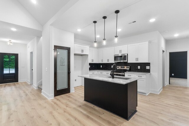 4410 Shiloh Canaan Rd, Palmyra, TN 37142 - kitchen featuring stainless steel appliances, a sink, light wood-type flooring, white cabinetry, and decorative backsplash