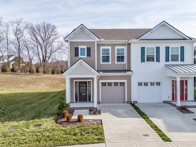 view of front of home with a front yard, an attached garage, and driveway