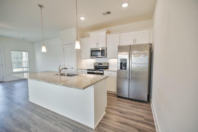 kitchen with visible vents, white cabinetry, stainless steel appliances, and a sink