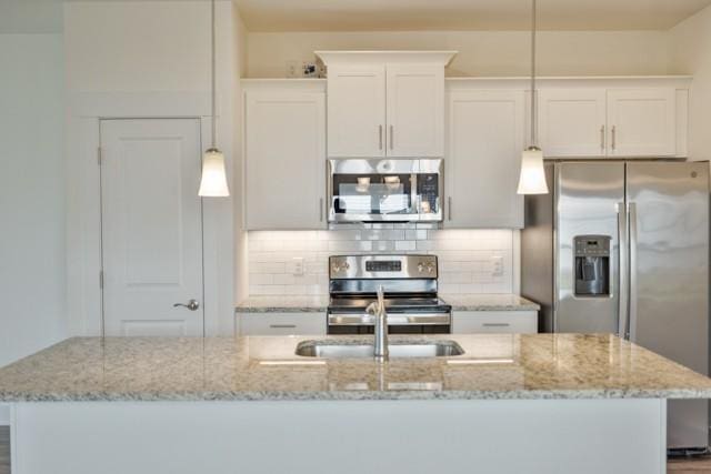 kitchen with backsplash, light stone countertops, and appliances with stainless steel finishes