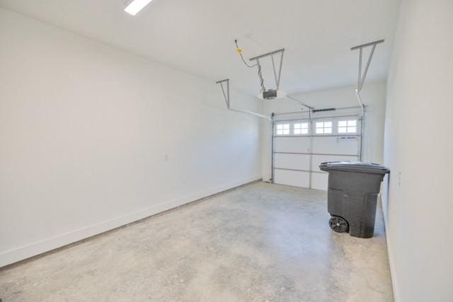 garage with a garage door opener and baseboards