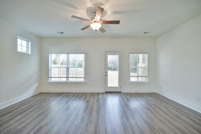 interior space featuring visible vents, plenty of natural light, wood finished floors, and baseboards