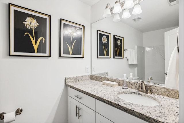 full bath with vanity, visible vents, and walk in shower