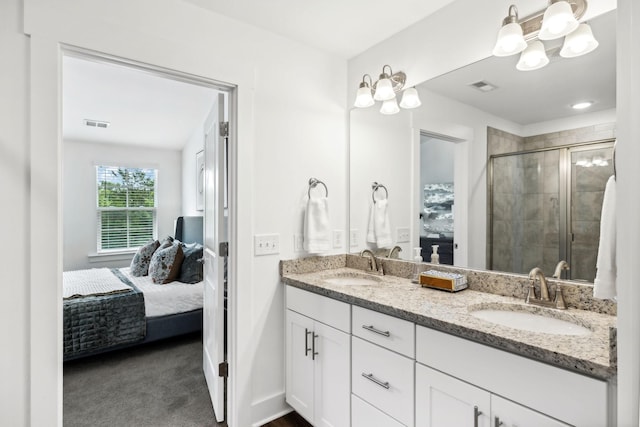 ensuite bathroom with a sink, visible vents, a shower stall, and ensuite bathroom