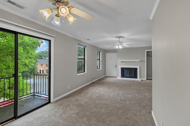 unfurnished living room with carpet, visible vents, ceiling fan, a glass covered fireplace, and crown molding