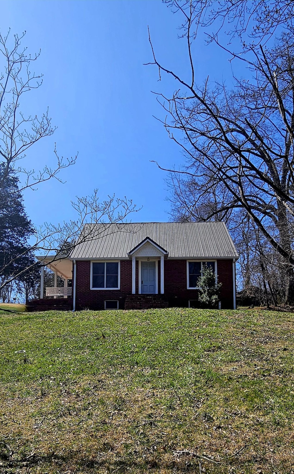 view of front of home with metal roof and a front yard