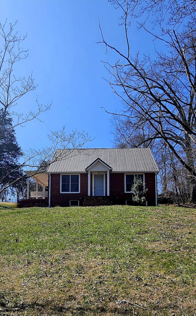 view of front of home with metal roof and a front yard