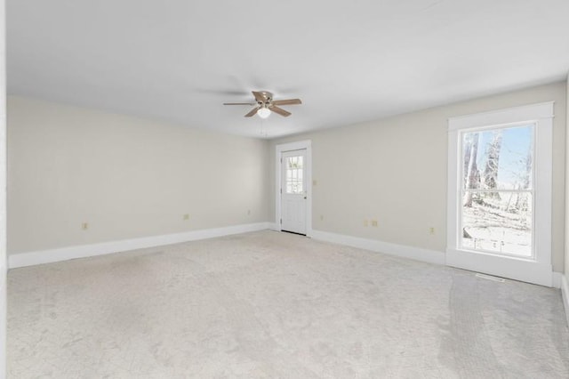 empty room featuring baseboards, light carpet, and ceiling fan