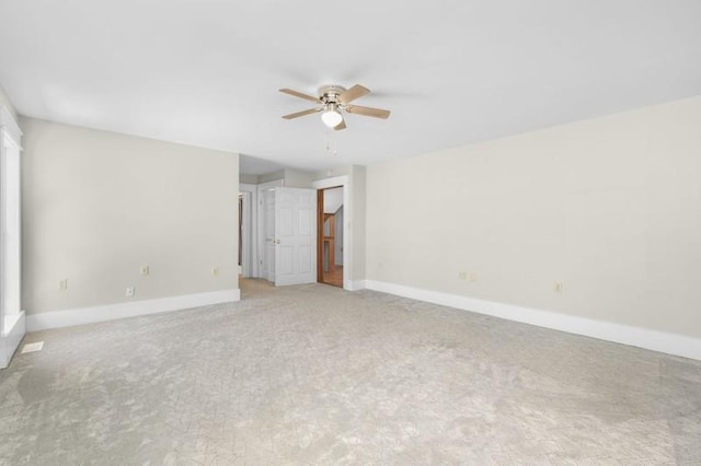 empty room featuring baseboards, light carpet, and a ceiling fan