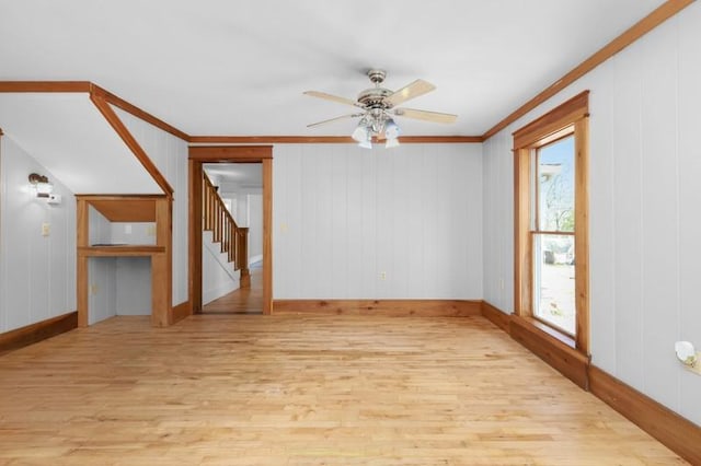 spare room featuring stairway, ornamental molding, ceiling fan, and wood finished floors