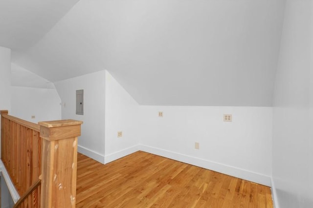 bonus room featuring electric panel, baseboards, and light wood-style floors