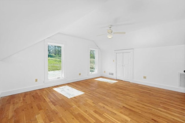 additional living space featuring baseboards, lofted ceiling, light wood-style flooring, and a ceiling fan