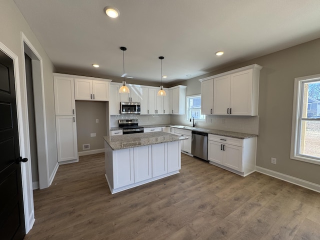 kitchen with white cabinetry, backsplash, appliances with stainless steel finishes, and a sink