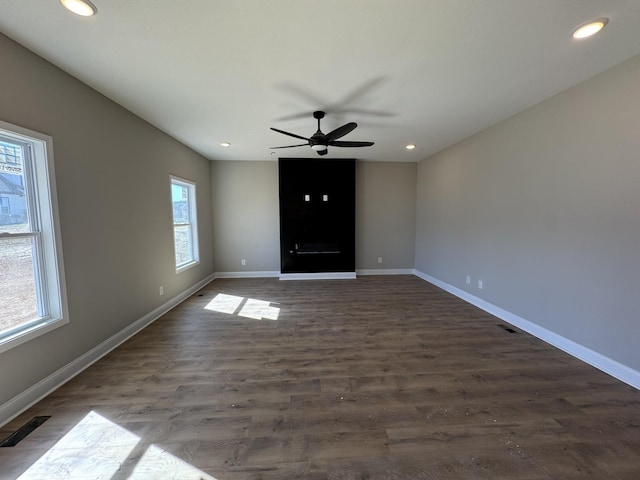 interior space featuring visible vents, a ceiling fan, recessed lighting, baseboards, and dark wood-style flooring