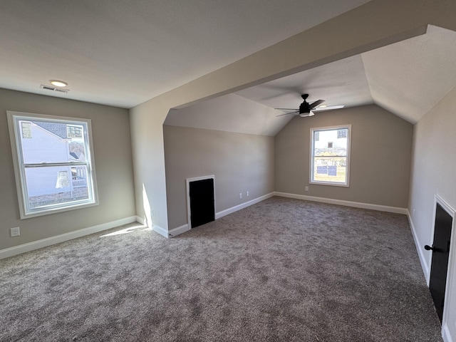 additional living space featuring carpet flooring, visible vents, baseboards, and vaulted ceiling