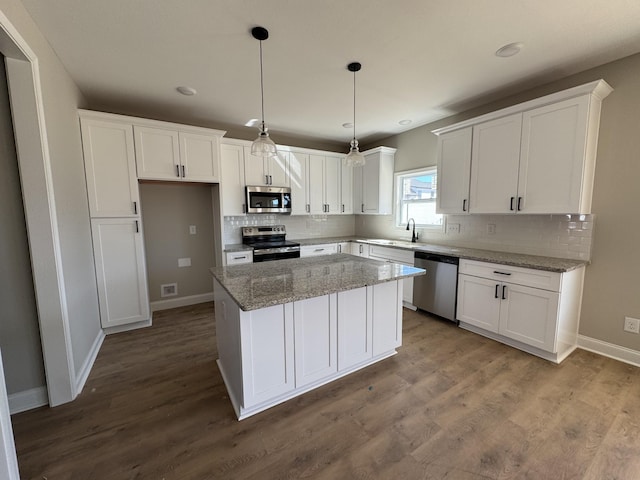 kitchen with stainless steel appliances, dark wood-style flooring, and white cabinetry