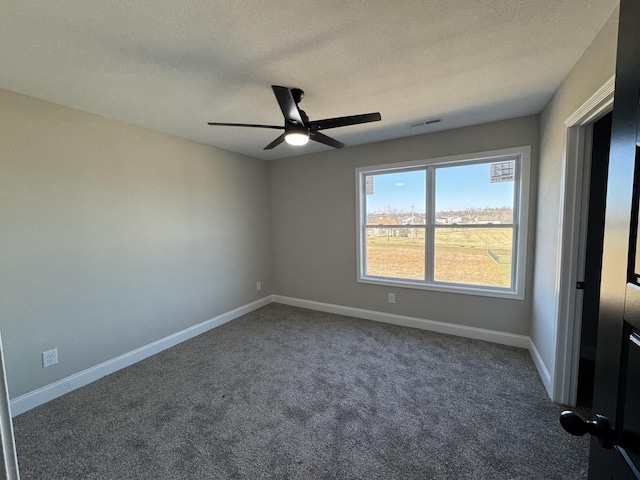 spare room with a ceiling fan, baseboards, visible vents, a textured ceiling, and carpet flooring