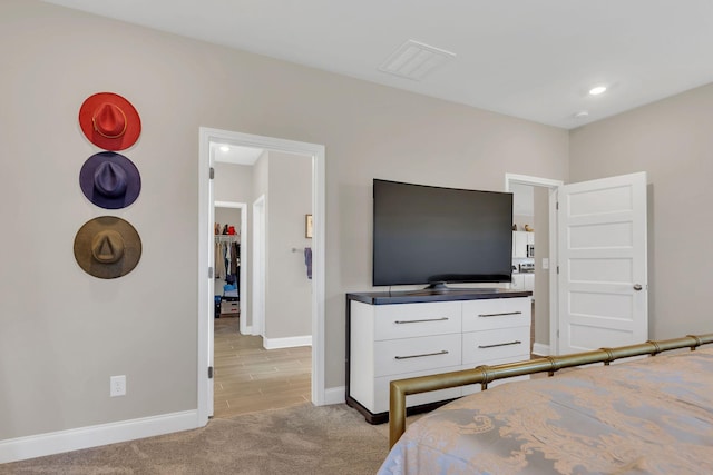 bedroom with light carpet, visible vents, and baseboards