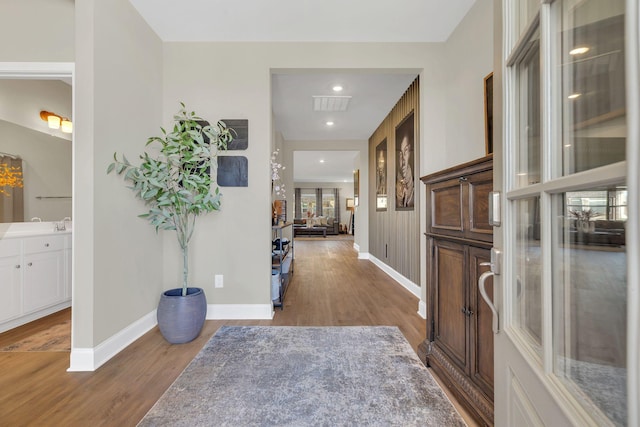 entrance foyer with wood finished floors, visible vents, and baseboards