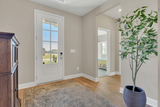 entryway featuring visible vents, baseboards, and light wood finished floors