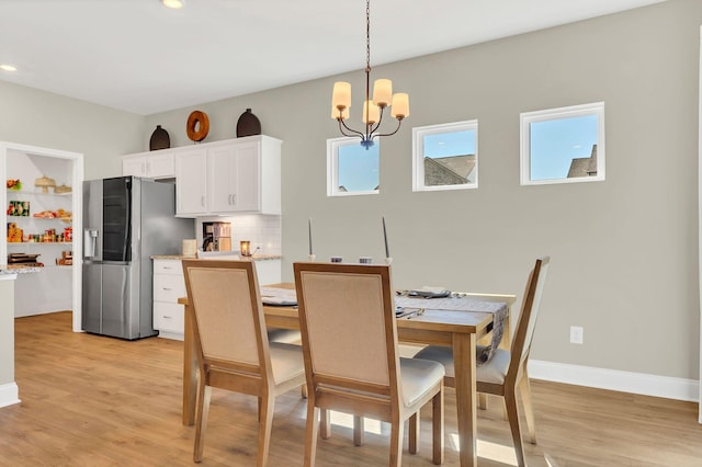 dining space with recessed lighting, baseboards, light wood finished floors, and a chandelier